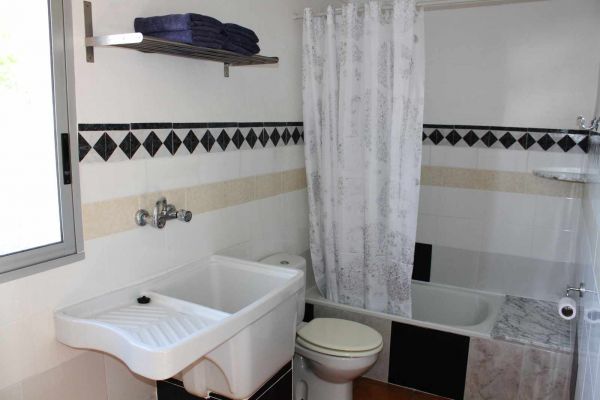 De badkamer met douche en klein badje.